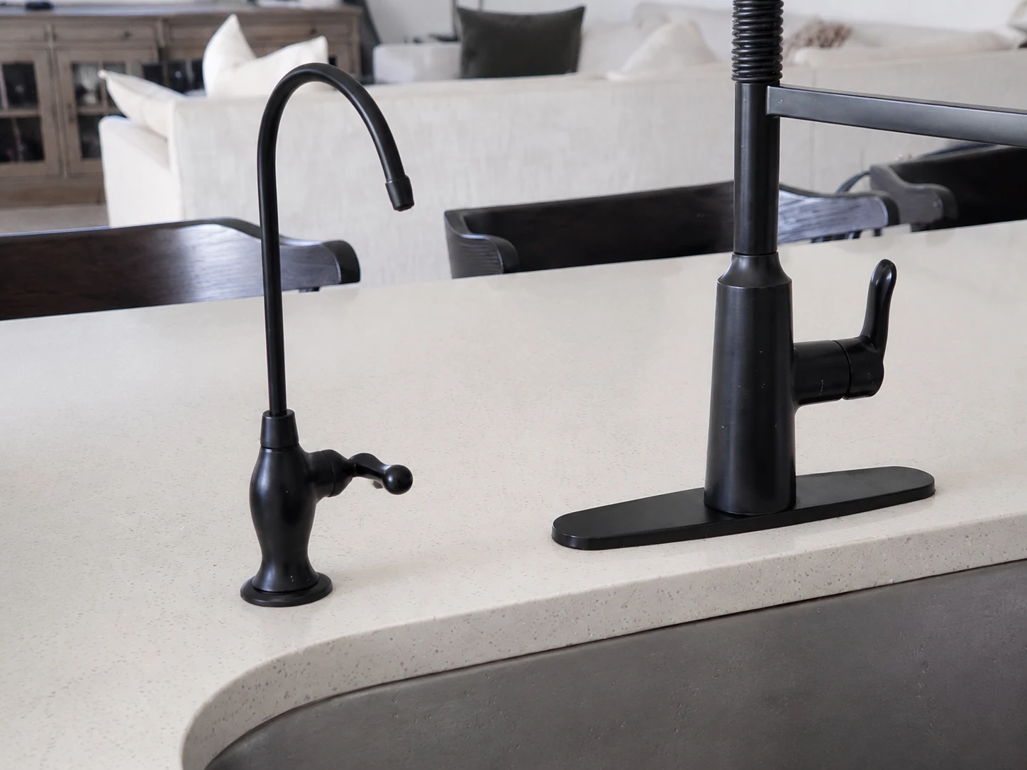 Matte-black drinking-water faucet beside the main kitchen faucet